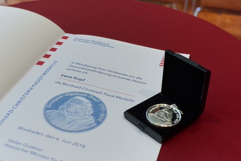 Eine Urkunde und eine Medaille liegen auf einem Tisch