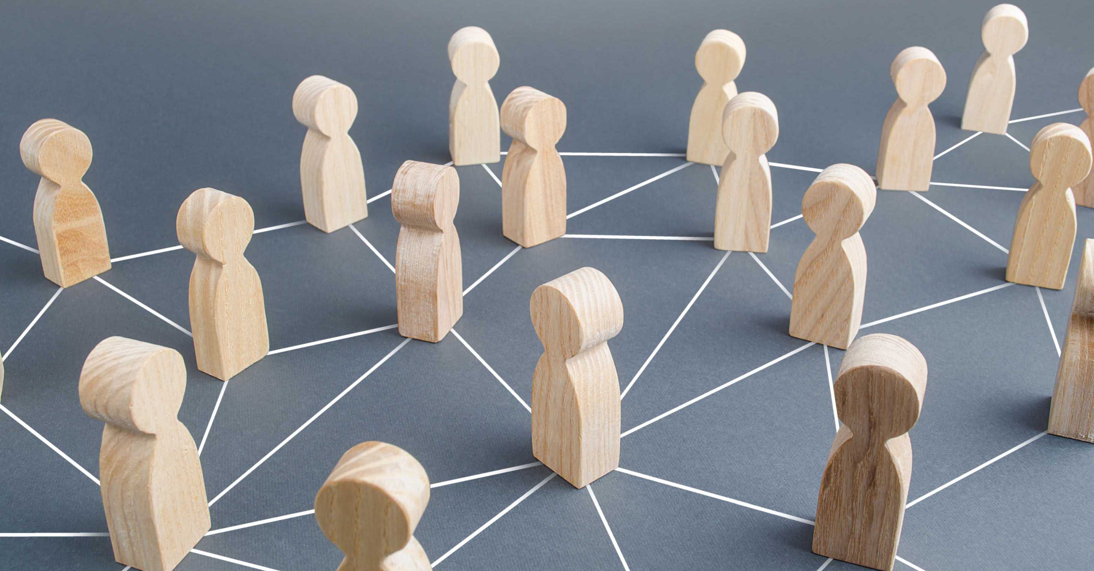 Holzfiguren stehen auf den Knotenpunkten eines Liniennetzes