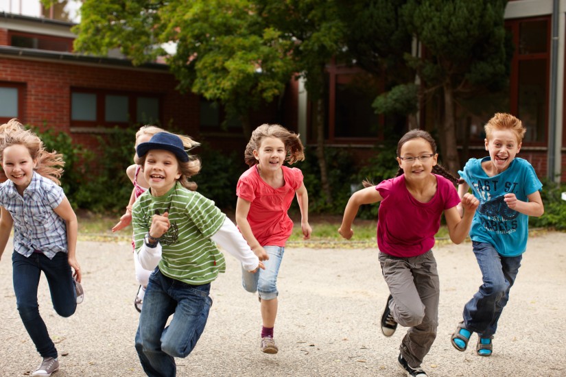Kinder rennen über einen Hof